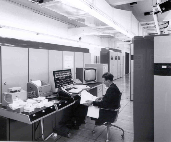 Engineer in front of console with bays 12b and 12c behind. Lift is at far end of room